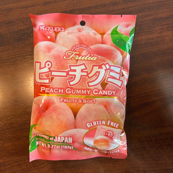 A pink bag of Kasugai Frutia Peach Gummy Candy, labeled "Product of Japan" and "Gluten Free".